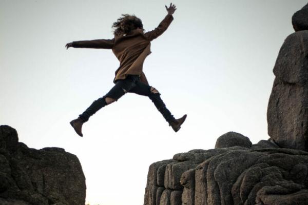 A person leaping from one cliff to another, signifying a quantum leap in technology